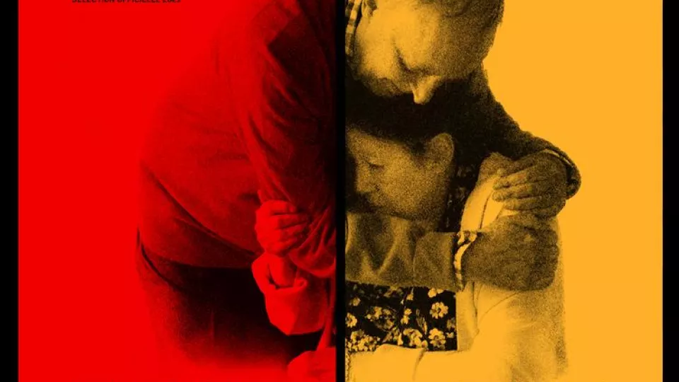 Vortex Filmplakat. Ein Mann der eine sitzende Frau umarmt. Linke Hälfte ist rot eingefärbt, rechte Hälfte gelb.