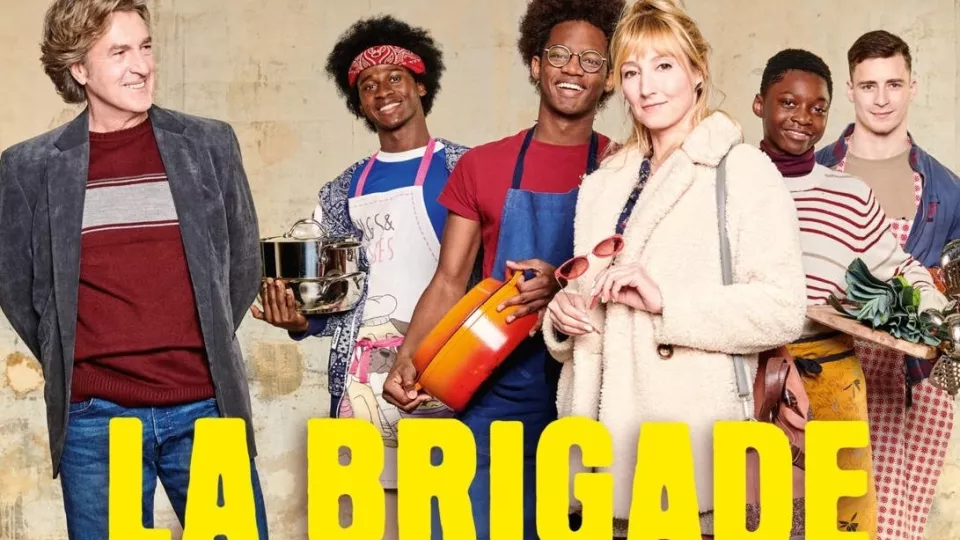 französisches Filmplakat Die Küchenbrigade. La Brigade. 4 jüngere Menschen und zwei ältere Menschen (Mann und Frau) stehen mit Kochutensilien rum.